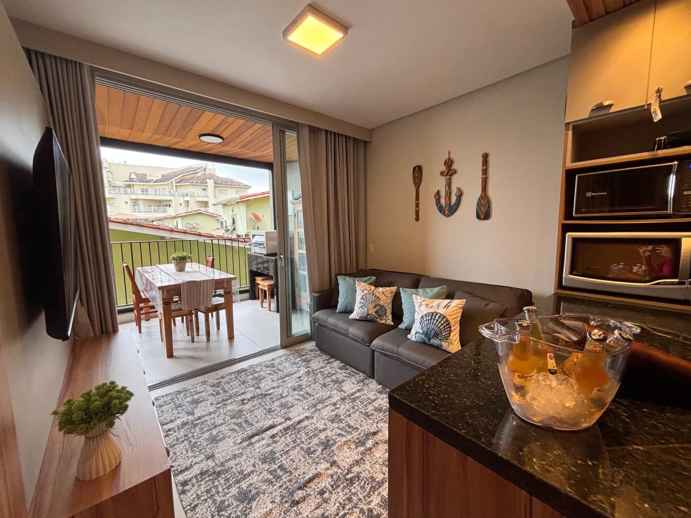 O ambiente, decorado em estilo praiano, proporciona conforto e aconchego para toda a família. A TV 55” compõe a sala integrada à varanda gourmet, criando o cenário perfeito para aproveitar a