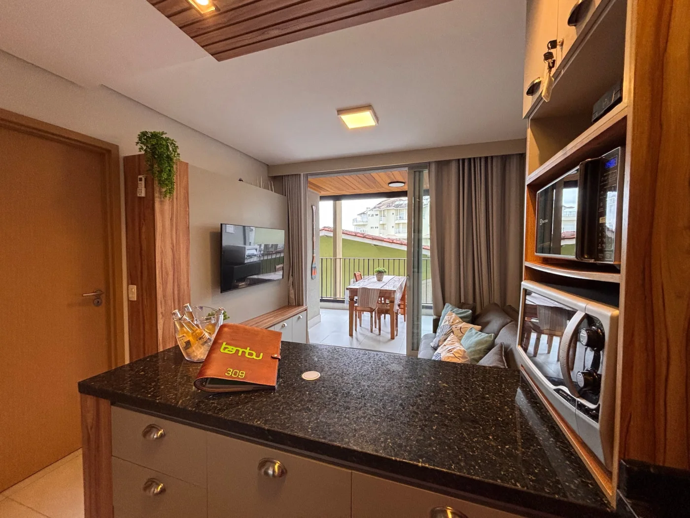 Ambiente integrado de cozinha, sala de estar e varanda gourmet, projetado para oferecer conforto, sofisticação e praticidade. Com uma decoração litorânea, os espaços amplos e harmoniosos con