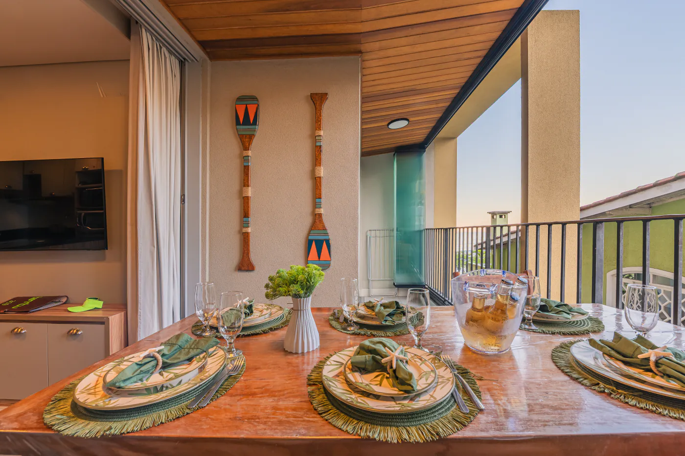 Mesa posta na varanda gourmet, com vista aberta da sala
