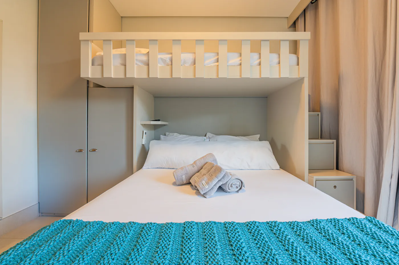 Quarto com cama de casal e beliche visto de frente