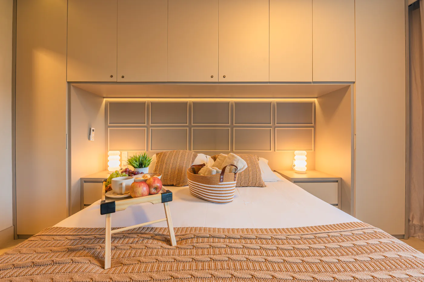 Suíte com cama de casal, iluminação quente e armários planejados