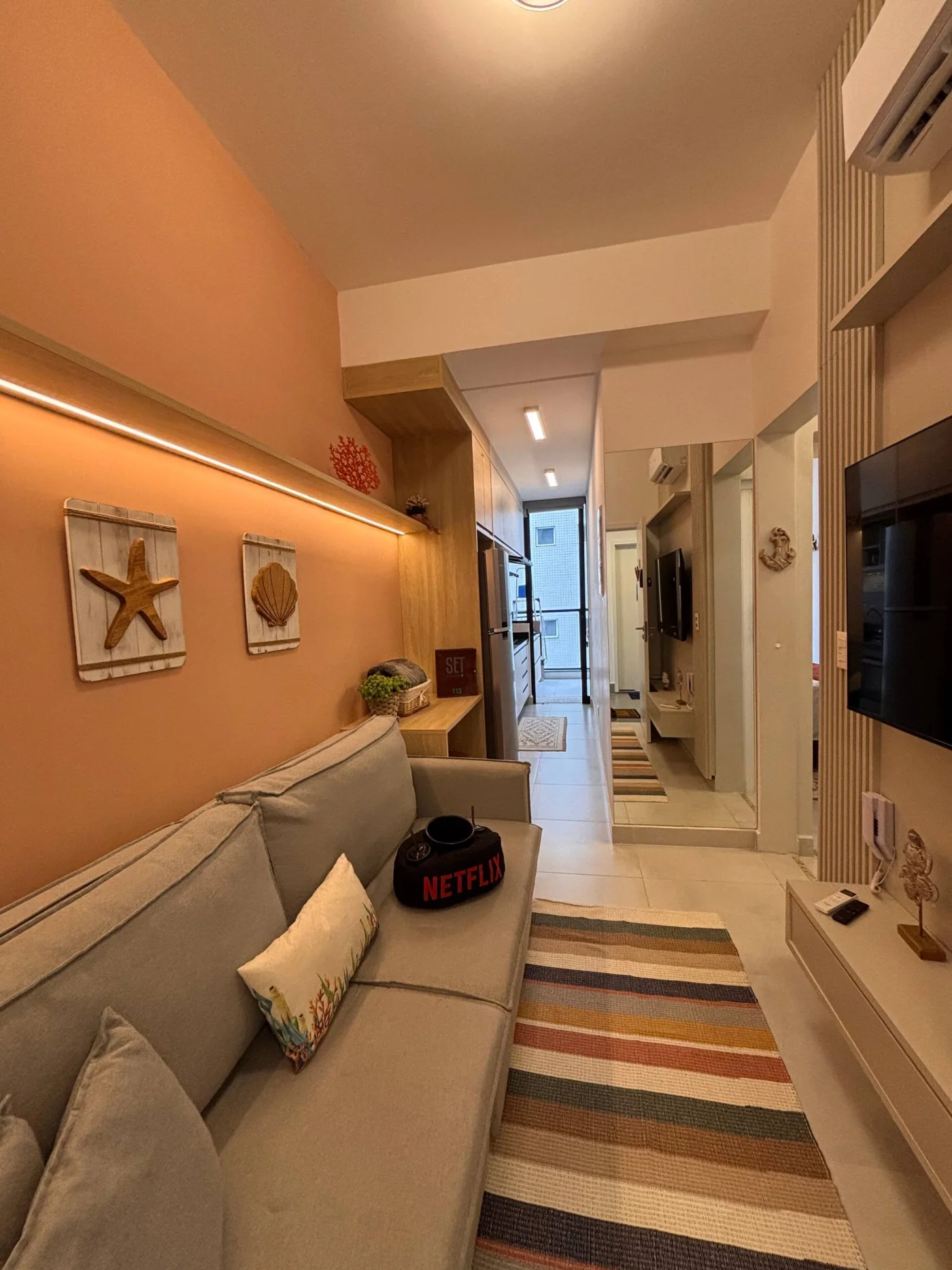 Sala de estar acolhedora e cheia de charme, inspirada na leveza do litoral e pensada para momentos especiais a dois. O ambiente oferece sofá confortável, TV e Wi-Fi, criando o cenário perfei