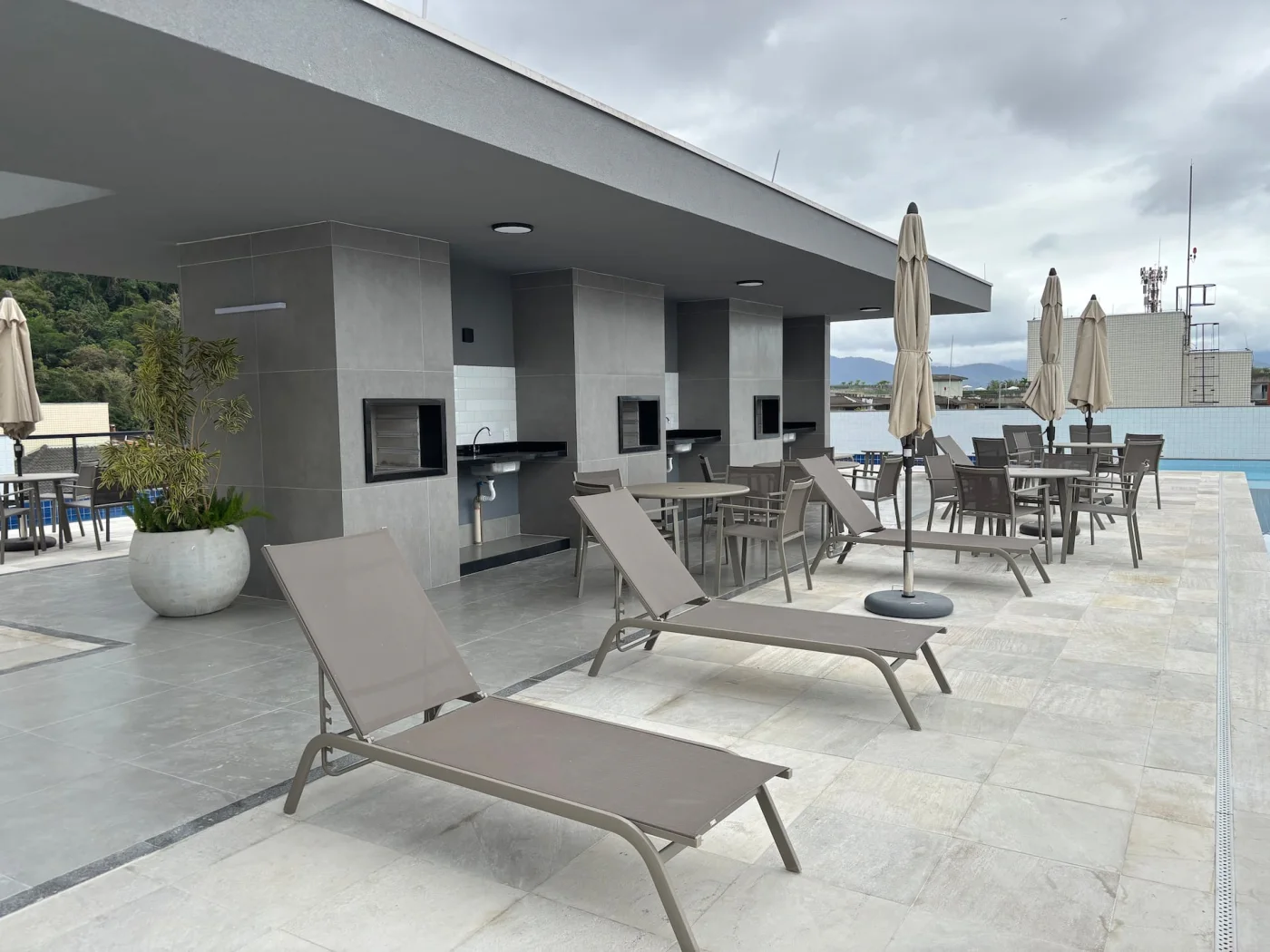Terraço com espaço de descanso e espreguiçadeiras, ideal para relaxar, aproveitar o sol e contemplar a vista em total conforto e tranquilidade.
