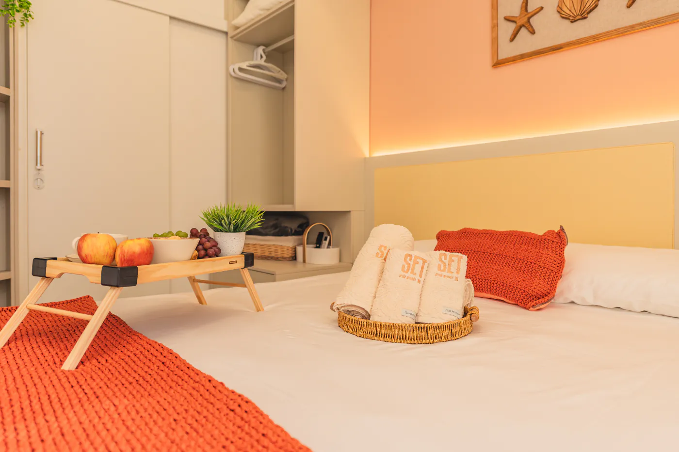 Cama de casal com bandeja de café da manhã e manta coral