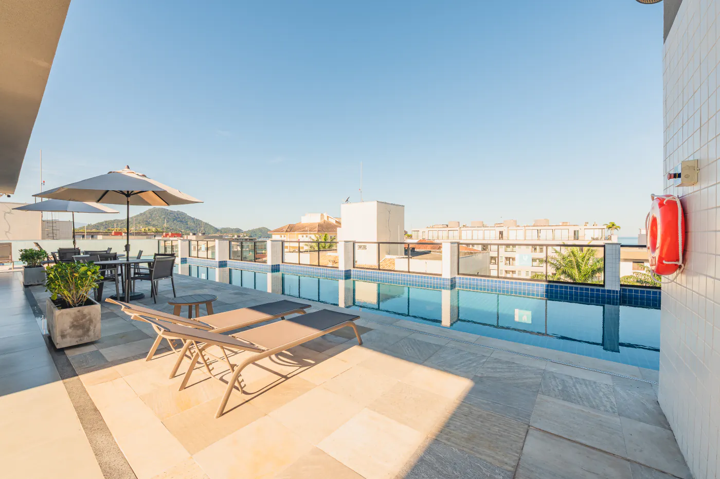 Piscina em U na cobertura com espreguiçadeiras